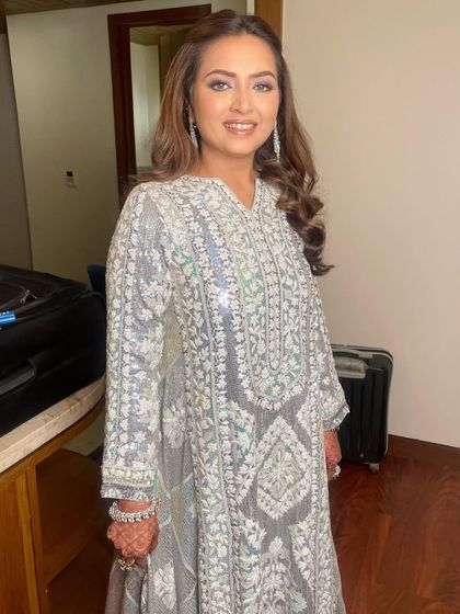 The full look is effortlessly chic. The soft makeup and hair balance the heavy embroidery of her outfit, creating a harmonious and elegant style.