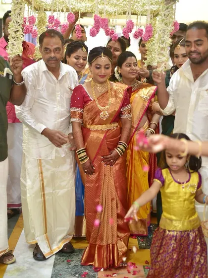 A beautiful shot of a South Indian bride during her entrance, surrounded by family. Her golden saree and traditional jewelry make her look like royalty.