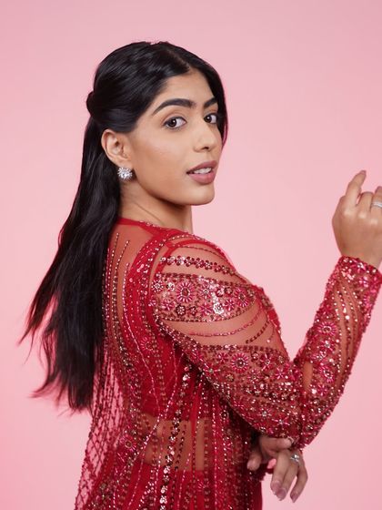 A close-up of the red three-piece Indo-Western set, highlighting the detailed embroidery on the sheer jacket.