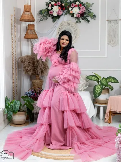 A stunning portrait in a pink ruffled gown. The layers of tulle and the soft color create a romantic and feminine look in the boho setting.
