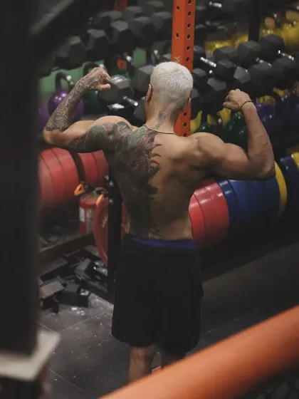 The back of a fighter tells a story of countless hours of pull-ups, rows, and deadlifts. This is the physique required to control an opponent in the clinch or on the ground.