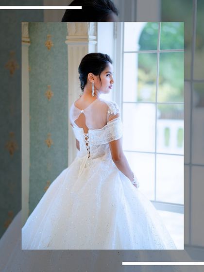A view of the back of the white gown, showing the elegant corset lacing and sheer sleeves.
