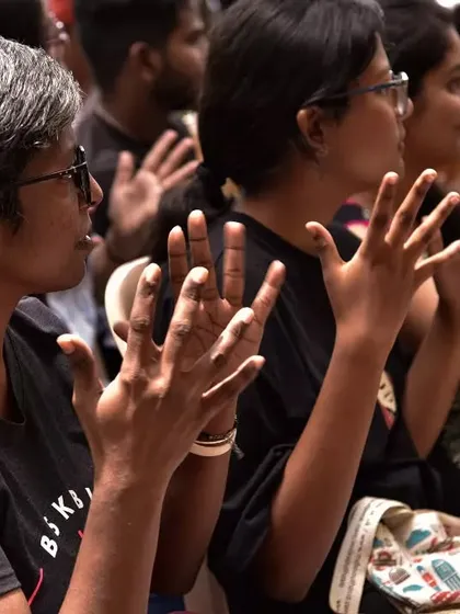 The audience participates in a sign language lesson. We believe in interactive learning, where everyone gets to practice and engage.