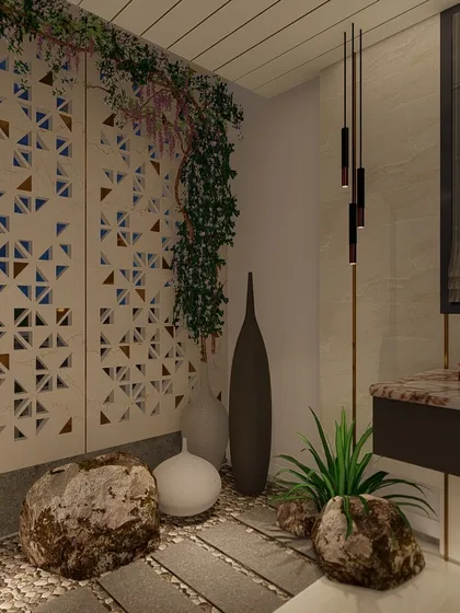 A detail shot of the nature-inspired bathroom, showing the use of large rocks, pebbles, and climbing plants against a geometric jali screen. This corner is designed to feel like a private garden.