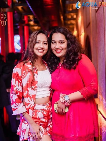A stylish duo in red and white at The Fixx, enjoying the weekend vibes.