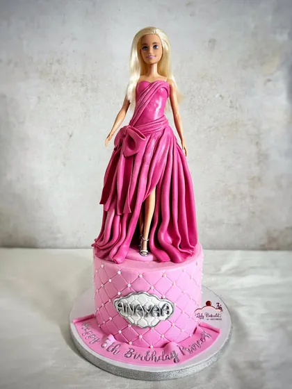 All dolled up and ready for the party! This Barbie cake features a stunning, entirely edible gown with intricate draping and texture, all made from fondant.