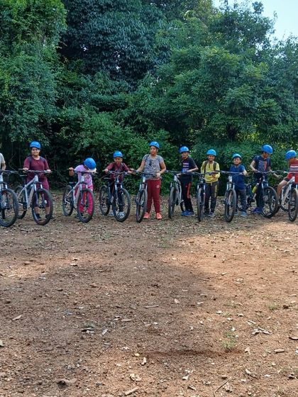 A team of mountain bikers lines up with their bikes, ready to start their 18km ride through the trails of Barapole.