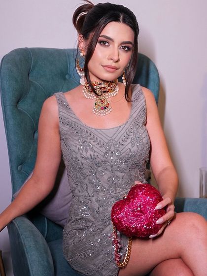 A fun and glamorous shot featuring a sparkling heart-shaped clutch. The makeup is elegant and polished, perfect for a night out or a special celebration.