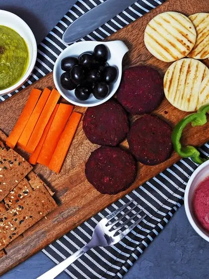 A healthy and appetizing grazing board with various types of hummus, crackers, and fresh vegetables. This demonstrates my ability to shoot savory and health-focused food platters for cafes and catering businesses.