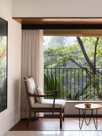 We create intimate moments within a home, like this quiet seating area for two. By perfectly framing the lush greenery outside, we turn a simple window into a private retreat, blending the interior with nature.