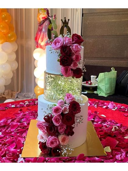This 3-tier spacer cake was the star of a 60th birthday party. The middle tier is filled with fairy lights and baby's breath, while the cake is adorned with a cascade of fresh roses.