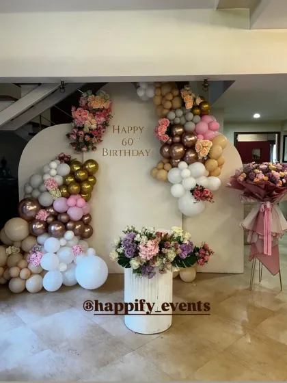 Marking a milestone 60th birthday with elegance and style. This sophisticated backdrop combines a soft color palette with beautiful floral arrangements and a custom balloon garland, proving that celebrations can be both grand and graceful at any age.