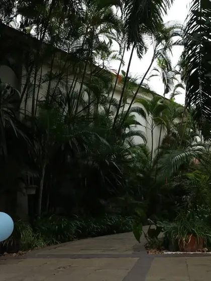 The entrance to the venue, showing the welcome sign placed along a path surrounded by lush greenery.