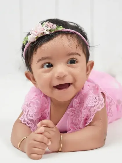 The pure delight of a six-month-old. This baby girl's happy expression during her tummy time is absolutely priceless. Sitter sessions are perfect for capturing these emerging personalities.
