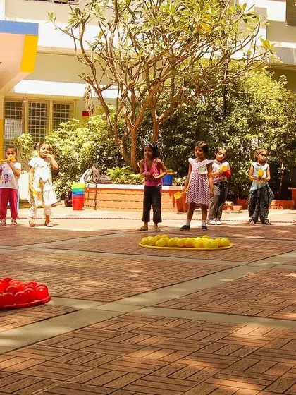 Students are organized into teams for a ball-sorting game, a fun team building activity that encourages quick thinking and collaboration. Each team works to gather their color balls into the hoop.