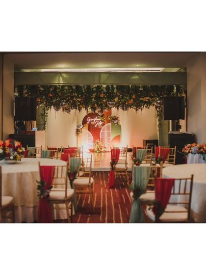 The reception seating area, with tables dressed in white and chairs adorned with drapes in shades of sage green and rust, perfectly matching the autumn color palette.