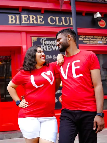 A fun and vibrant shot in front of a red pub facade. The couple's matching "LOVE" t-shirts are perfect for this urban setting.