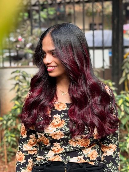 We're obsessed with this wine red hair color. Accessorized with flowers, this look is romantic, bold, and absolutely beautiful.
