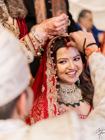 The beautiful sindoor moment. I love capturing these candid shots where the bride's happiness and the beauty of the makeup shine through.