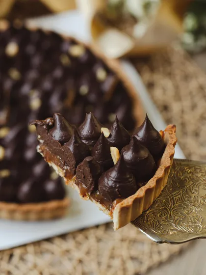 This is my take on a classic candy bar, transformed into an elegant tart. A crisp, buttery crust holds a layer of gooey caramel and roasted peanuts, topped with rich dark chocolate ganache.