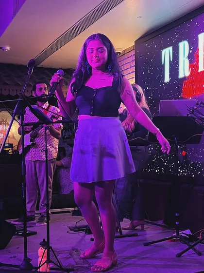 A full-length shot of me on stage during a club gig. This shows a typical performance look, which is modern, comfortable, and stylish.