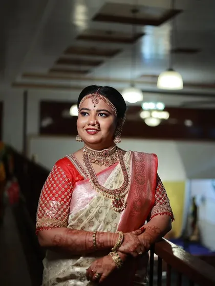 This bride is wearing a heavy, antique Kempu set, complete with a matha patti, for her Muhurtham. This is a very traditional and royal look.