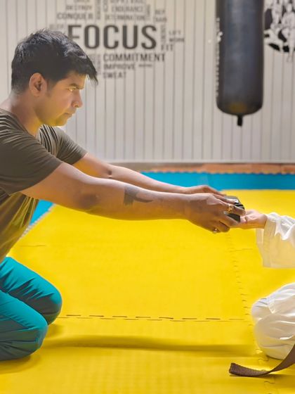 A close-up of the belt ceremony, a significant and personal moment between the coach and the student.