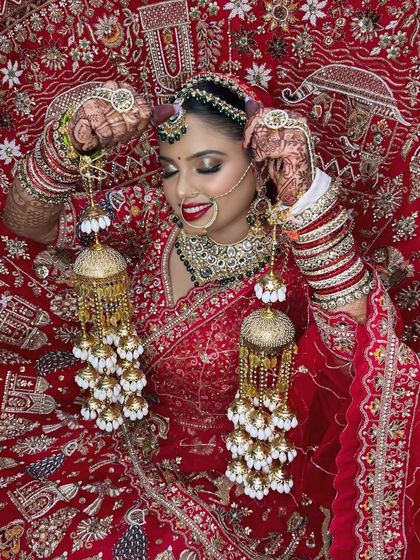 A candid moment of the bride with her kalire. The rich red of her lehenga and lipstick creates a vibrant and celebratory look.