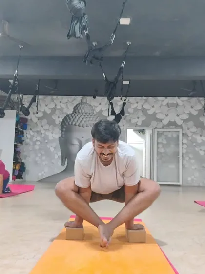 A student uses blocks to support his feet in Malasana (Garland Pose). This modification helps to open the hips safely and is a great example of foundational prop use.