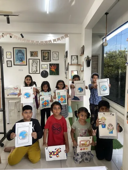 A group of proud students from our kids' class holds up their finished artwork. There's nothing better than seeing the sense of accomplishment on their faces after completing a project.