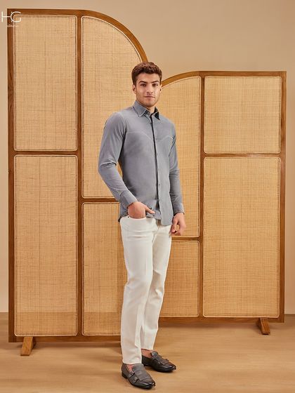 This full-length look shows the grey corduroy shirt paired with white trousers, an effortlessly stylish combination for a smart casual occasion.