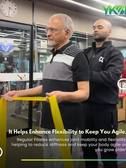 Regular Pilates enhances joint mobility and flexibility, helping to reduce stiffness as you age. This client is working with a thera-band to keep his body agile.