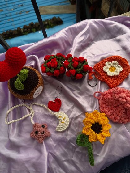 A flat lay of some of my favorite giftable items. You can see a potted sprout, a star and moon car charm, a single sunflower, and other cute pieces perfect for any occasion.