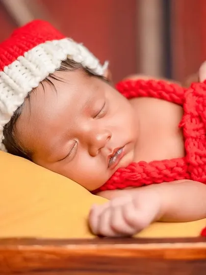 The soft lighting in the studio creates a gentle glow on the baby's skin, perfect for capturing that newborn innocence.