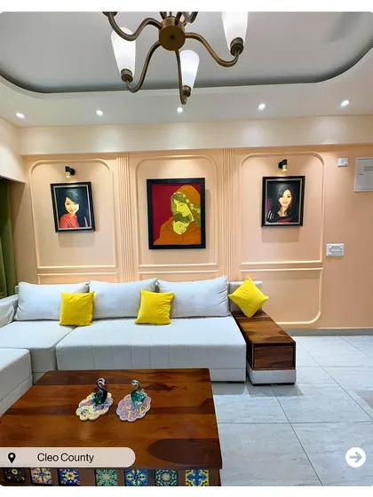 This living room is designed around the client's art collection. The peach-colored walls with classic molding provide a perfect gallery-like backdrop for the vibrant paintings.
