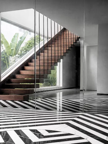 This image captures the striking geometry of the Tellado staircase and its relationship with the large glass panels. The design ensures that even transitional spaces are filled with light and connected to the outdoors.