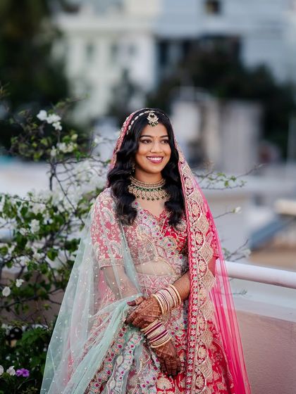 A North Indian bridal look perfect for a reception. The makeup is soft and romantic, with a focus on the eyes and a flawless base.