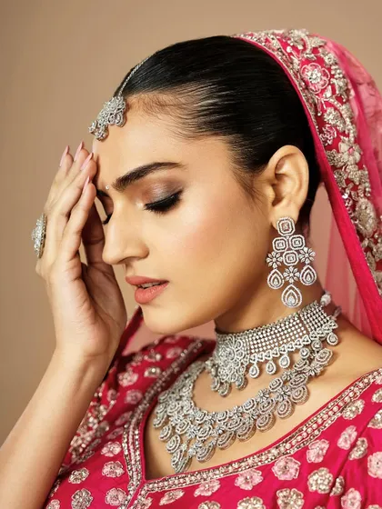 A moment of quiet elegance. This shot highlights a soft smokey eye and contoured cheeks, creating a sophisticated look for this bride in her vibrant pink attire.