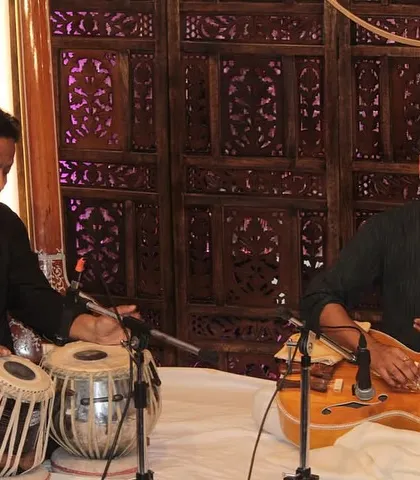 Two instrumentalists, one on tabla and the other on Hawaiian guitar, in perfect sync during a performance.
