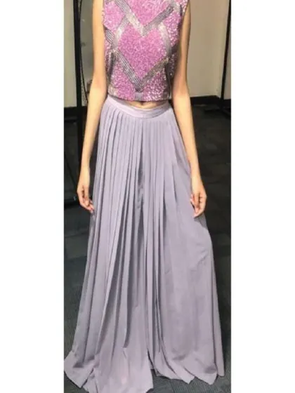 This stylish two-piece set includes a sleeveless crop top with a geometric sequin pattern and wide-legged pleated palazzo pants. It's a comfortable yet fashionable alternative to a traditional lehenga for a sangeet or party.