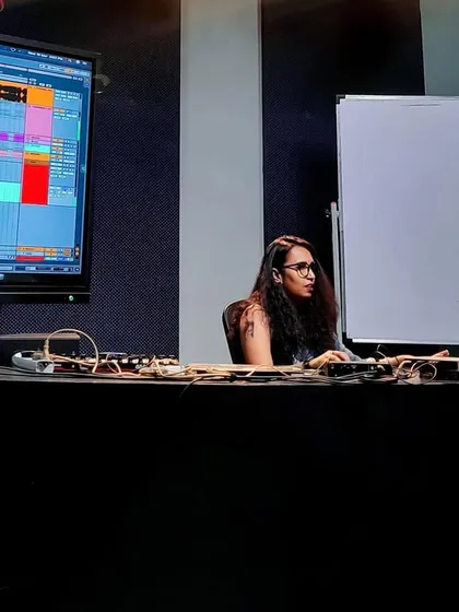 A focused moment during a production masterclass. The large screen displays my Ableton project, where I'm deconstructing a Drum & Bass track to show my arrangement and sound design techniques.