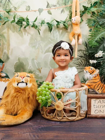 A personalized jungle-themed first birthday for Tara, complete with animal props and a custom sign.