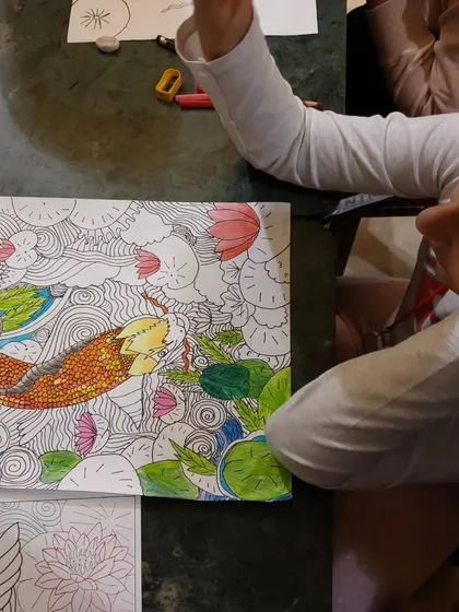 A moment of contemplation. This student is taking a short break, admiring her progress on the colorful and detailed lucky carp painting.