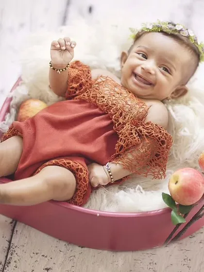 A big, happy smile from this little one during her apple-themed sitter session. Her joy is absolutely contagious.