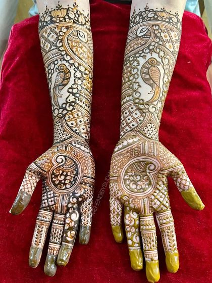 The full two-hand view of the parrot and paisley engagement design.