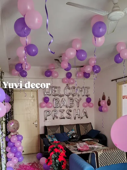A view of the ceiling balloons and the "Welcome Baby Prisha" foil balloon banner.