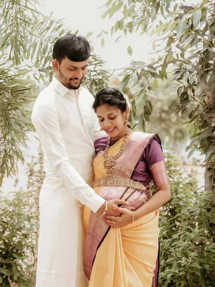 Another gentle moment between a couple during their outdoor maternity shoot. The focus is on their hands and the baby bump, symbolizing their shared journey into parenthood.