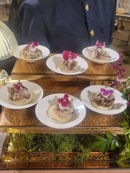 A modern twist on a classic. Our Zatar Chicken Tikka is served on small bread discs and garnished with edible flowers, blending Middle Eastern spices with an Indian favourite.