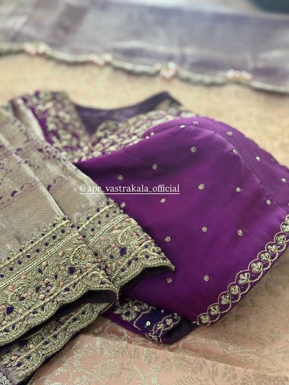 A purple blouse with contrasting silver-gold sleeves, both heavily embroidered.