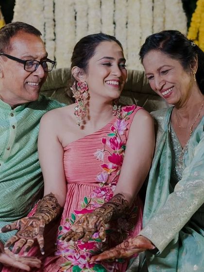 A heartwarming moment of a bride sharing her mehandi-adorned hands with her parents.